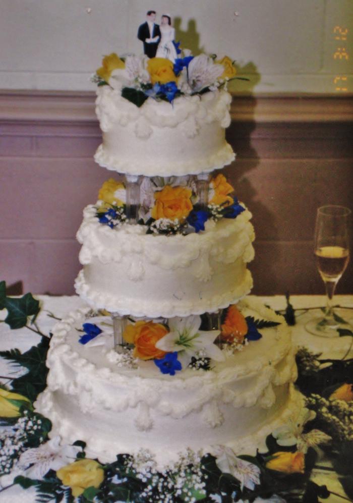 buttercream wedding cake with roses, lilies, delphinium