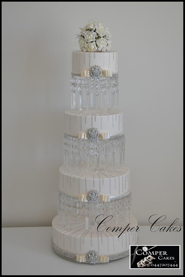 Tall wedding cake on crystal stand.
