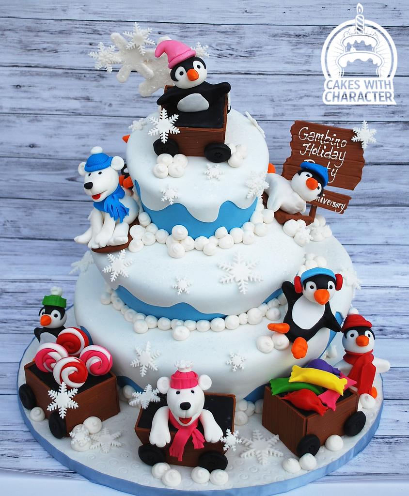 Little Bee Bakery - Penguin themed 1st birthday cake. 4 layers of white  chocolate and raspberry cake, sandwiched with raspberry buttercream.  Covered in pale blue buttercream and decorated with fondant snowflakes and
