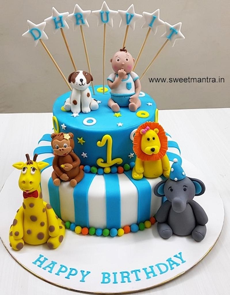 Animals theme 2 tier cake with 3d boy figurine for 1st - CakesDecor