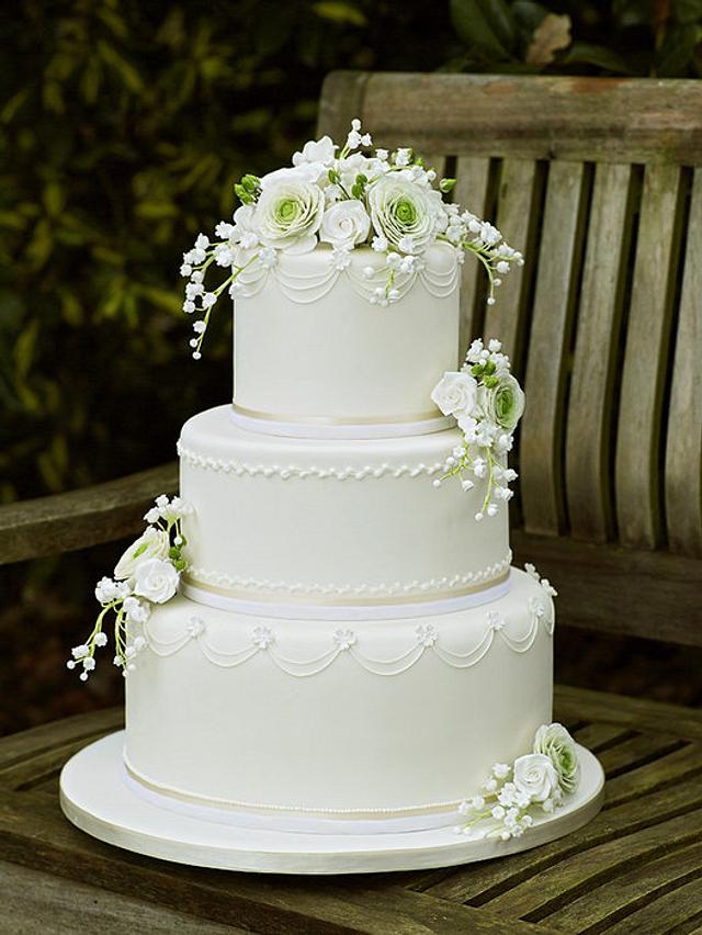 White Wedding Cake with ranunculus, roses and lily of the - CakesDecor