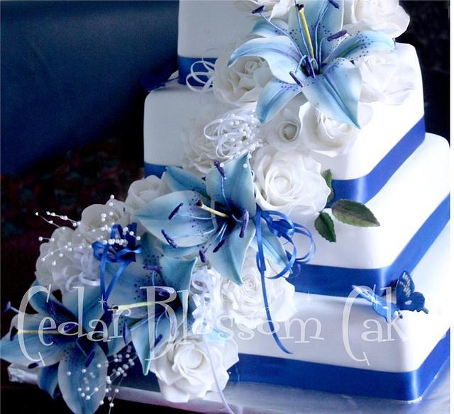 Blue lilies and white rose wedding cake
