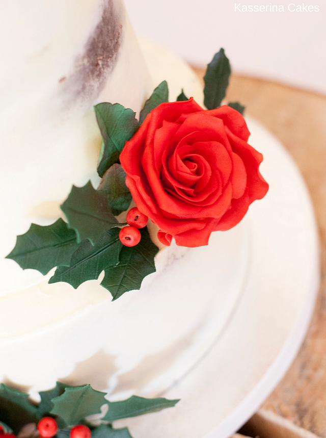 Semi-naked wedding cake with red sugarpaste roses and holly
