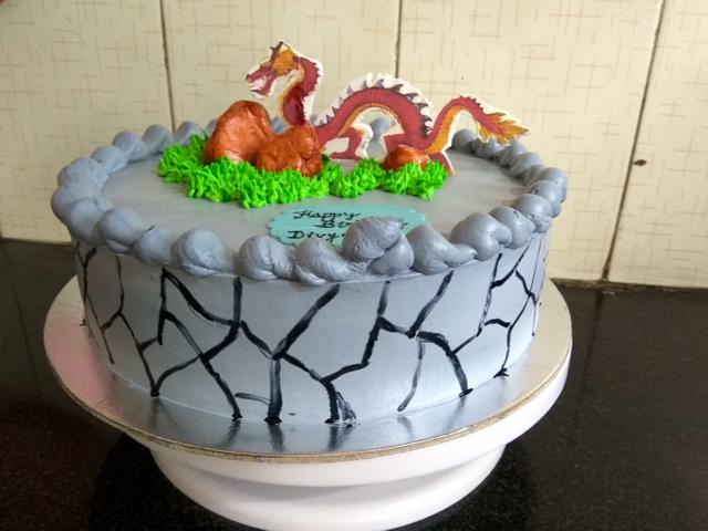 A castle theme cake with dinosaur taking over it and ruling it. – Creme  Castle
