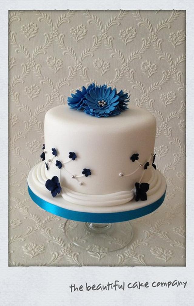 Gerber daisy on wedding cake. A bright red gerbera daisy adorns a summer wedding  cake. | CanStock