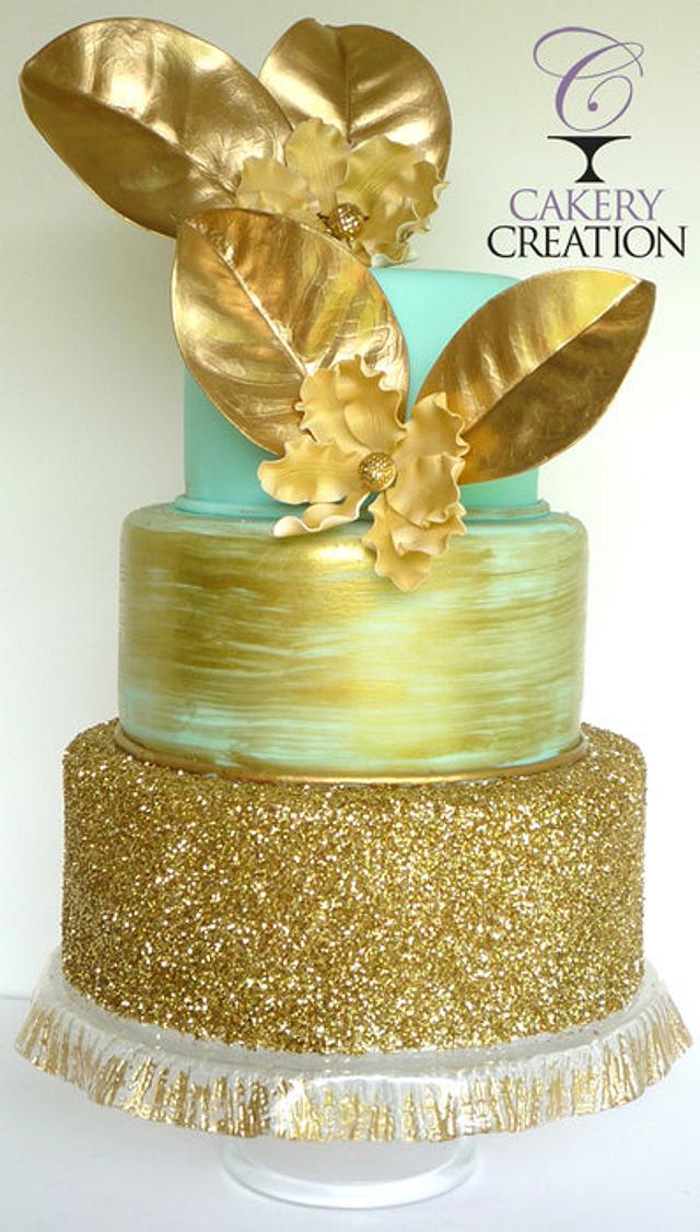 Gold and seafoam green wedding cake and dessert table