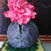 cake with green wood, painted feathers and rock with moss and wafer flower