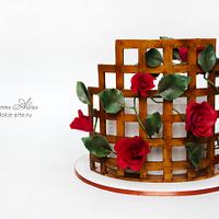 Cake with a rose at a wattle fence