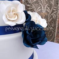 wedding cake with white roses and blue