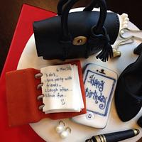 Birthday cake with Mulberry bag Chanel shoe pearl earrings and necklace and an agenda