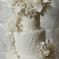 White wedding cake white flowers and lace