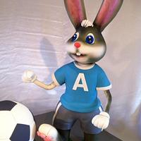 A bunny kicking a soccer ball cake ! 