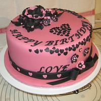 Pink & black birthday cake with hearts & flowers