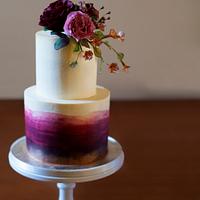 Dark ombré two tier cake with touches of gold and sugarpaste flowers.