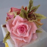 square pale mauve and white cake with flowers