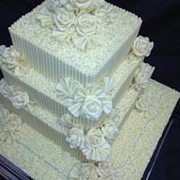 3 tier white belgium chocolate with fans and white roses white curls wedding cake