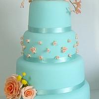 Blue cake with orange roses and freesias, and mimosas