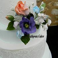 Pale blue and white wedding cake with sugar flowers