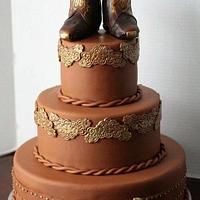 Cowboy wedding cake with edible boots on top.