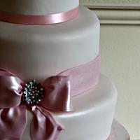 Simple cake with edible bow and brooch