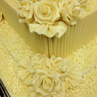 3 tier white belgium chocolate with fans and white roses white curls wedding cake