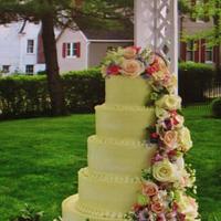 Buttercream wedding cake w/ cascading fresh flowers