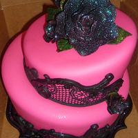 Halloween/Bday cake in hot pink with black surgarveil lace. Roses and stand glow under black light