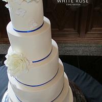 Five Tier Ivory Wedding Cake with Roses and Royal Blue Trim 