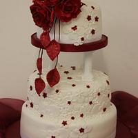 Embossed wedding cake with red rose topper