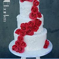 red roses on a white laced weddingcake