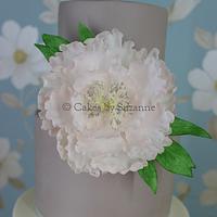 Taupe and ivory wedding cake with pale pink peony