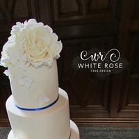 Five Tier Ivory Wedding Cake with Roses and Royal Blue Trim 