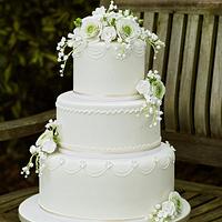 White Wedding Cake with ranunculus, roses and lily of the valley