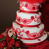 Three tiered Red and White Paisley print wedding cake with a red feather topper