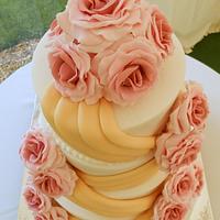 pink roses and gold sashes 4 tier wedding cake