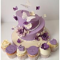2 tier topsy turvy engagement cake and cupcakes