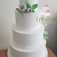 White wedding cake with lilac wired roses