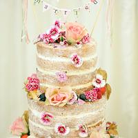 "Naked' cake with bunting and edible flowers