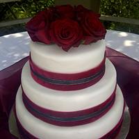 Elegant but simple wedding cake with red roses