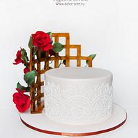Cake with a rose at a wattle fence