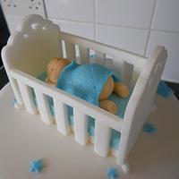 Baby in crib christening cake