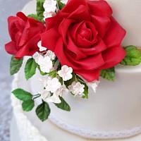 White wedding cake with red roses