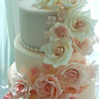 3 Tier Wedding cake in shades of pink with cascading roses