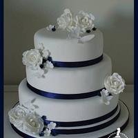Navy & white wedding cake with roses, blossom & butterfly details