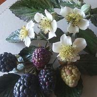 Arrangement of blackberries and flowers made from sugar.