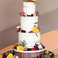 Semi naked wedding cake with fresh fruit and flowers
