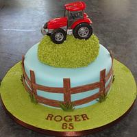 Red tractor birthday cake with wooden fence and grass hill