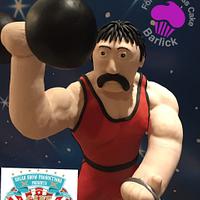 Stromboli the strong man from the fairground at twilight cake carnival room