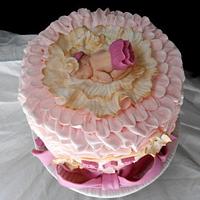 pink buttercream ruffle baby in a flower cake