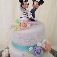 Pastel wedding cake with Mickey and minnie bride and groom 